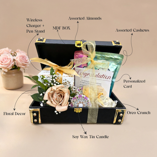 Gift set with various items labeled in an open black box on a beige background