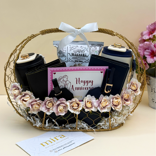Gift basket with black handbags and decorative flowers, featuring a 'Happy Anniversary' card.