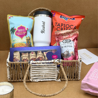 Gift basket with snacks and a tumbler on a brown background