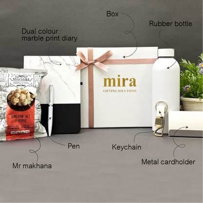 Gifting items including a marble print diary, box, rubber bottle, pen, keychain, metal cardholder, and Mr Makhana packaging on a gray surface.