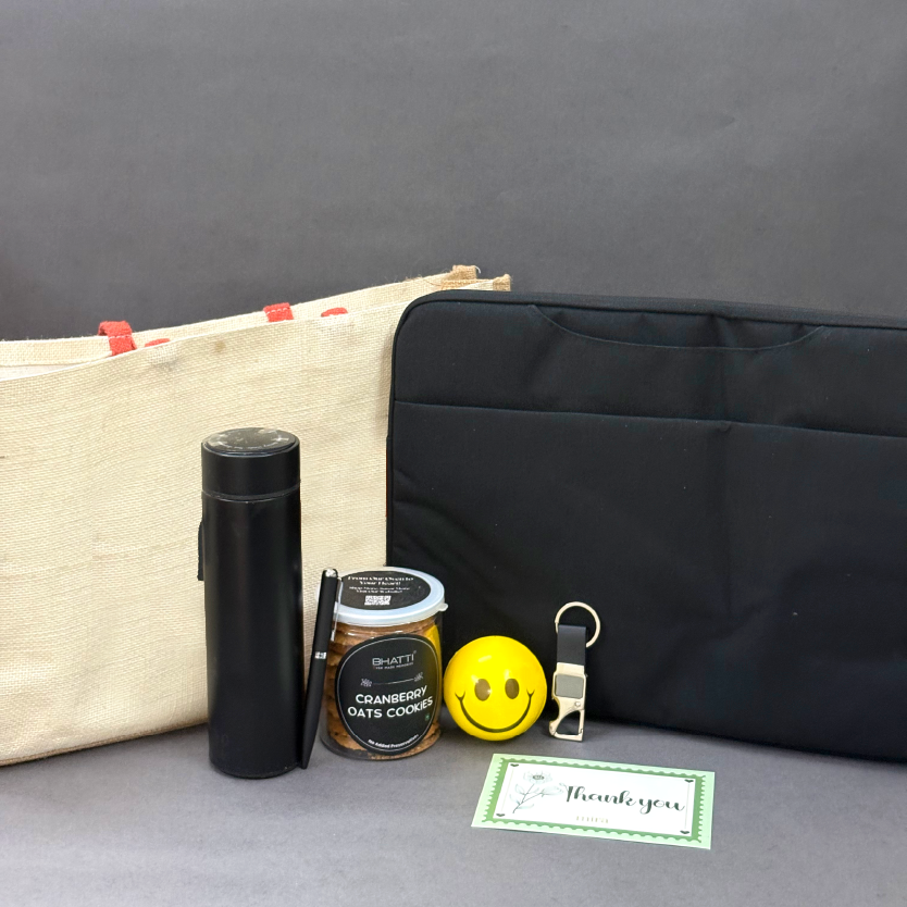 Black water bottle, jar, yellow smiley face keychain, black bag, and green card on a gray surface.