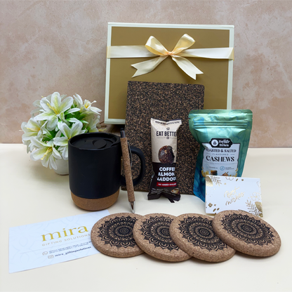 Gift set with coffee mug, snacks, and coasters on a beige surface