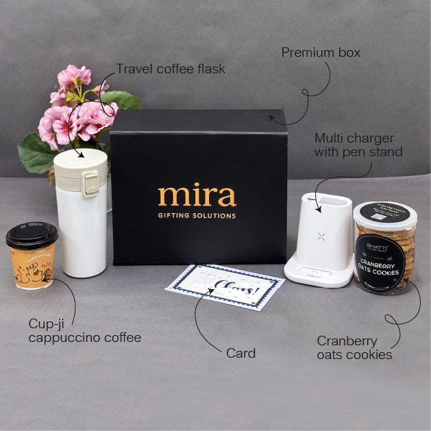Gifting set with 'mira' branded box, travel coffee flask, multi charger, cup-jj coffee, card, and cranberry oats cookies on a gray surface.