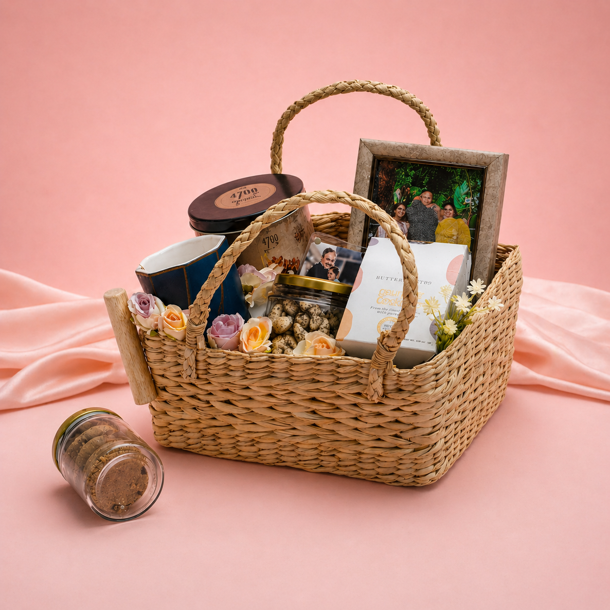 Woven gift basket with various items on a pink background