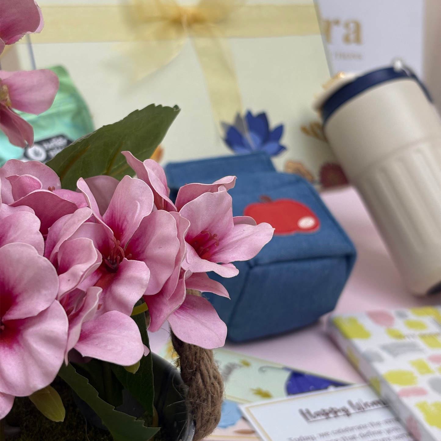 Pink flowers with a blurred background featuring a blue box and colorful items.