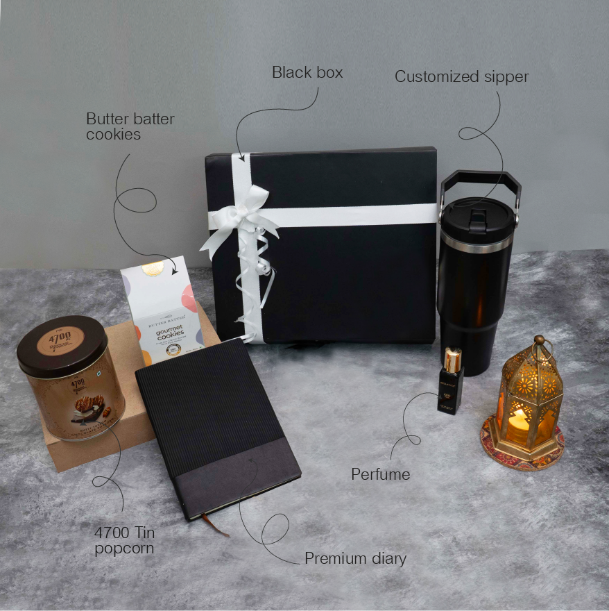 Collection of gift items including a black box, diary, popcorn tin, and other products on a gray surface.