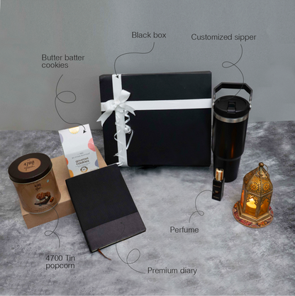 Collection of gift items including a black box, diary, popcorn tin, and other products on a gray surface.