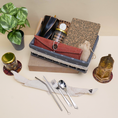 Set of cutlery and small items on a table with a plant and decorative objects.